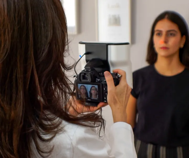 Doctora de Clínica Lunik realizando fotografía facial estandarizada a una paciente con la cámara Quantificare 3D